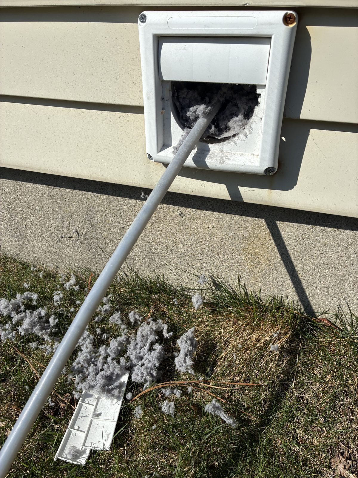 Technician cleaning an exterior dryer vent