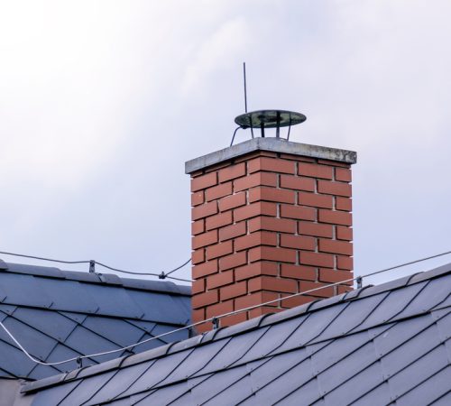 Repaired,Brick,Chimney,In,A,Forest,Hut,With,Dark,Roofing