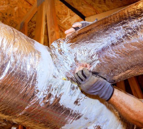 Workers,Are,Sealing,Duct,Connections,In,Attic,To,Ensure,Proper