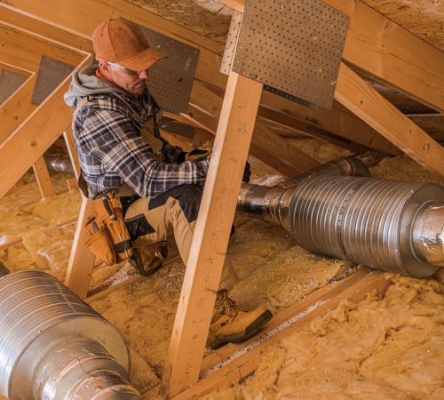 A,Skilled,Contractor,Is,Doing,Hvac,Work,In,An,Attic,